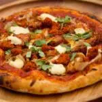 Delicious spicy pizza on wooden board.