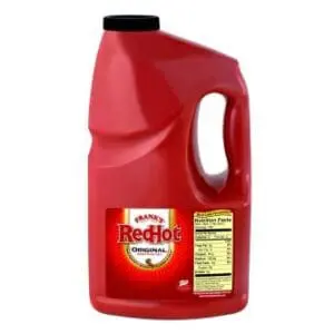 Large red plastic jug of Frank's RedHot Original Cayenne Pepper Sauce 3.78L, featuring the logo and nutritional facts, on a white background.