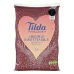 A package of Tilda Arborio Risotto Rice 5kg with a heart-shaped design containing grains, emphasizing its use for risotto.