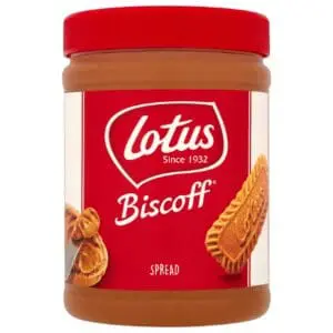 A jar of Lotus Biscoff Smooth Spread 1.6kg with a red label, featuring images of the biscuit and caramel drips.
