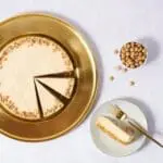 Sliced caramel cheesecake on gold plate.