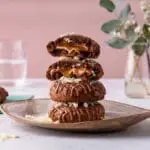 Chocolate caramel cookies stacked high.