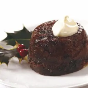 Christmas pudding with cream and holly.
