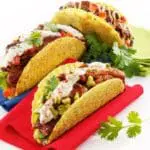 Three delicious tacos with toppings.