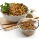 Spicy noodle bowl with dipping sauce.
