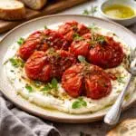 Slow-roasted Coeur de Bœuf tomatoes with whipped feta and fresh herbs.