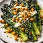 Charred cavolo nero cabbage topped with crispy chickpeas, shaved Parmesan and lemon zest, served as a restaurant-style Italian vegetable dish. Image and recipe created by Nicol Retailer Limited.