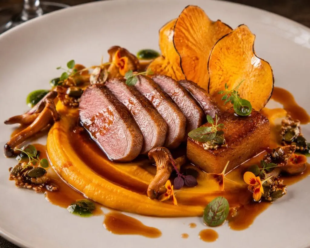 Michelin-star maple-glazed duck breast with roasted butternut squash three ways, burnt orange jus, pickled chanterelles and pumpkin seed brittle on an elegant fine-dining plate