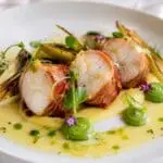 Michelin-inspired San Michele Speck-crusted monkfish with saffron cauliflower velouté, pea purée, charred leeks and Champagne beurre blanc, created by Nicol Retailer Limited