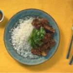 Here's an alt text suggestion for the image: Spicy eggplant dish with rice.