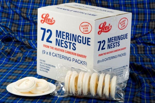 A box of Lees Meringue Nests (72 nests) with some Lees Meringue Nests (72 nests) displayed on a plate, sitting on a blue tartan fabric.