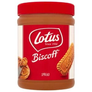 A jar of Lotus Biscoff Smooth Spread 1.6kg with a red label, featuring images of the biscuit and caramel drips.