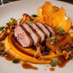 Michelin-star maple-glazed duck breast with roasted butternut squash three ways, burnt orange jus, pickled chanterelles and pumpkin seed brittle on an elegant fine-dining plate
